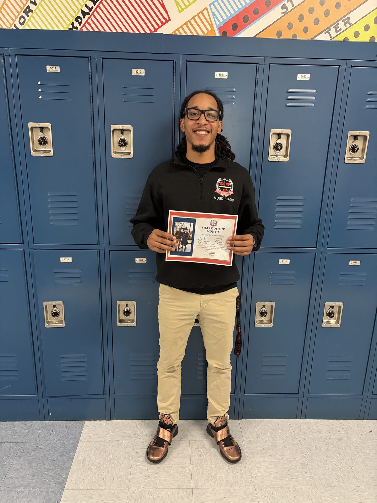 Quayon Boone holding his Shark of the Month certificate