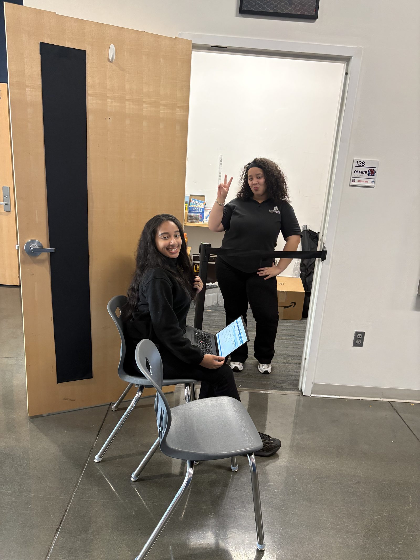Two Newark Lab students running the school store outside Office 128